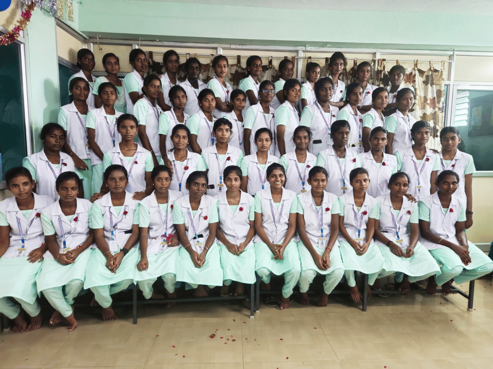 Vinayaga nursing students in green and white uniforms – group photo with red rose decorations