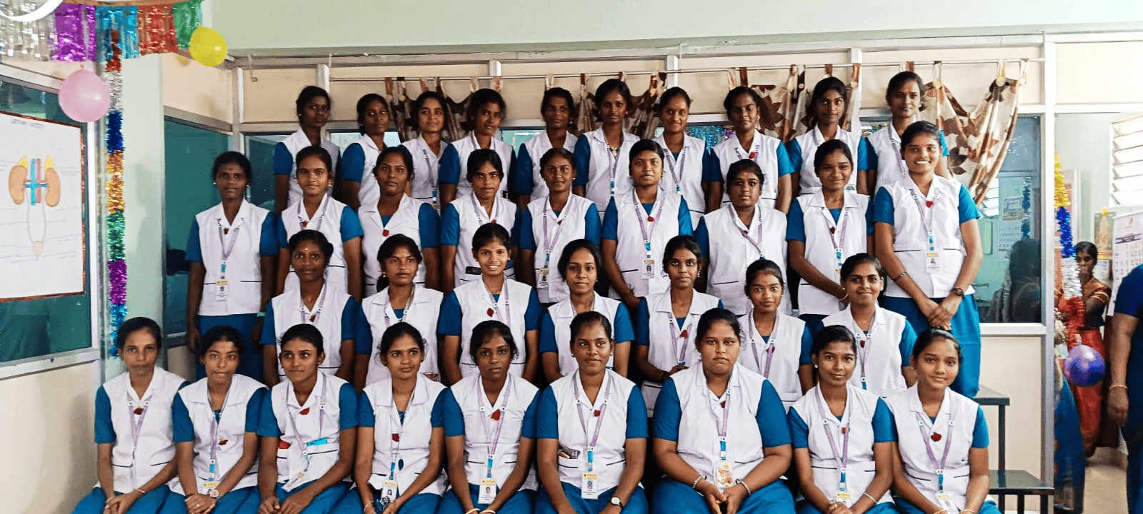 Vinayaga nursing college CHN batch in blue and white uniforms – festive group photograph with colorful decorations
