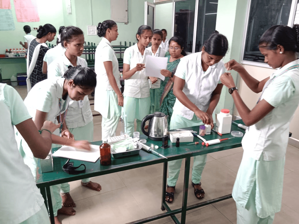 Vinayaga nursing students performing practical training – medication preparation and nursing skills at lab table