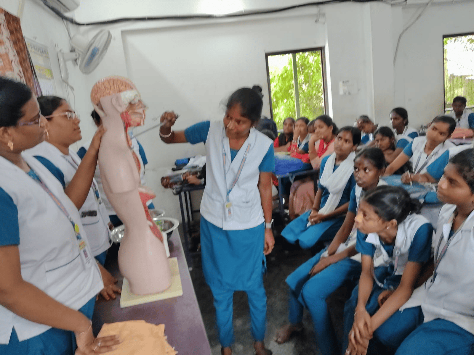Vinayaga nursing faculty demonstrating human anatomy using a full-body model in a classroom session